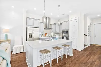 a kitchen with white cabinets and a large white island at Skippy's Hideaway in Inlet Beach