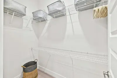 a bathroom with white walls and a wicker basket at Skippy's Hideaway in Inlet Beach