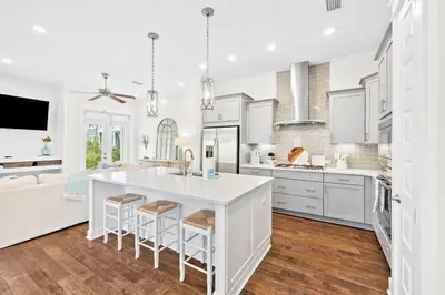 a kitchen with white cabinets and a large island at Skippy's Hideaway in Inlet Beach