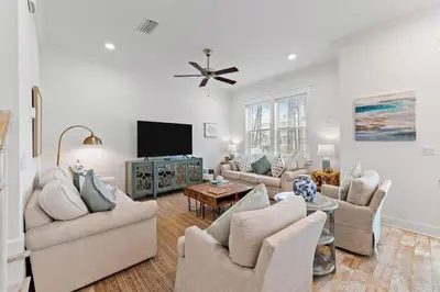 a living room with couches and a flat screen tv at License to Chill in Inlet Beach