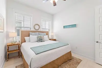 a bedroom with a large bed with white walls at License to Chill in Inlet Beach