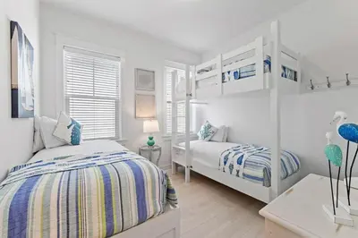 a white bedroom with two beds and a window at License to Chill in Inlet Beach