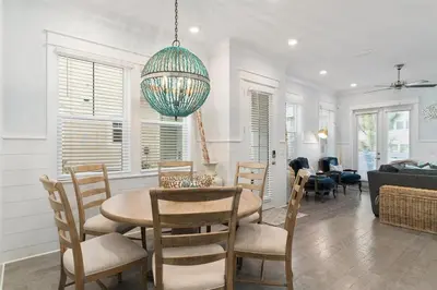 a dining room and living room with a table and chairs at Isle be 'SEA'ing You in Inlet Beach