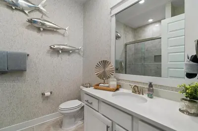 a bathroom with a sink and a toilet and a mirror at Isle be 'SEA'ing You in Inlet Beach