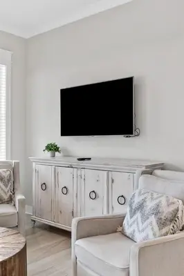 a living room with a television on a white wall at Isle be 'SEA'ing You in Inlet Beach