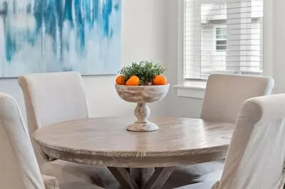 a dining room table with oranges in a bowl on it at Isle be 'SEA'ing You in Inlet Beach