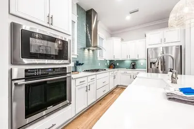 a kitchen with white cabinets and stainless steel appliances at BeachHaven 30A in Inlet Beach