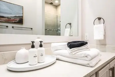 a bathroom with a sink with towels and a mirror at BeachHaven 30A in Inlet Beach