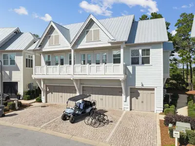 a house with a golf cart parked in front of it at Sand Dollar Dream in Inlet Beach