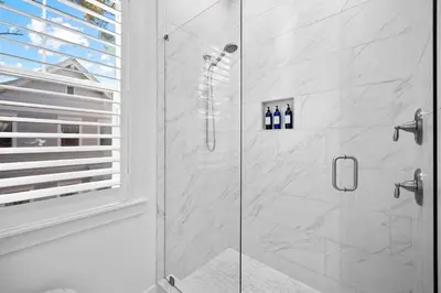 a bathroom with a shower with a glass door at Doc's House in Inlet Beach