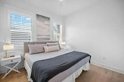 a white bedroom with a bed and a window at Doc's House in Inlet Beach