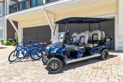 a golf cart parked in front of a house with bikes at SaltLife30A in Inlet Beach