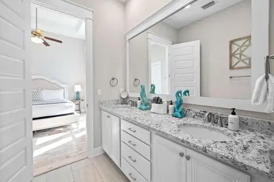a white bathroom with a sink and a mirror at Surfers Retreat in Inlet Beach