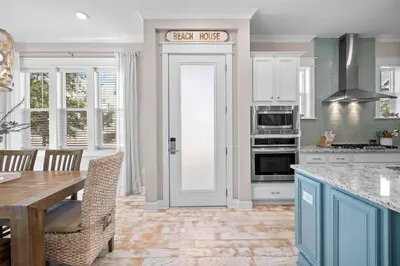 a kitchen with a table and a door with a sign on it at Surfers Retreat in Inlet Beach