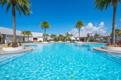 a large swimming pool with palm trees in a resort at Serenity Sunset in Inlet Beach