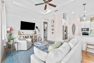 a living room with a white couch and a tv at Coastal Beauty in Inlet Beach