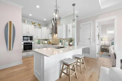 a kitchen with white cabinets and a large island at Coastal Beauty in Inlet Beach