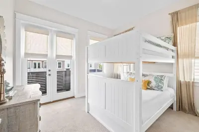 a white bunk bed in a white room with windows at Coastal Beauty in Inlet Beach