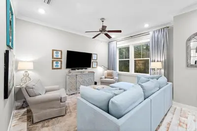 a living room with a couch and a tv at Endless Summer in Inlet Beach
