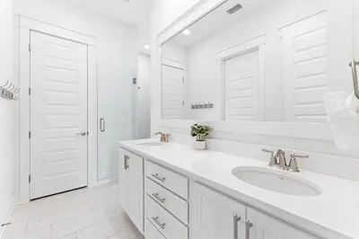 a white bathroom with a sink and a mirror at Just Add Water in Inlet Beach