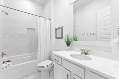 a white bathroom with a toilet and a sink at Just Add Water in Inlet Beach
