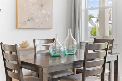 a dining room table with two glass vases on it at Just Add Water in Inlet Beach
