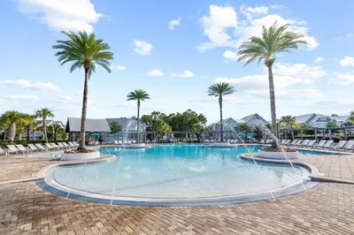 a large swimming pool with palm trees in a resort at Just Add Water in Inlet Beach