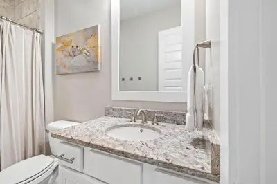 a white bathroom with a sink and a toilet at The Tipsy Turtle in Inlet Beach