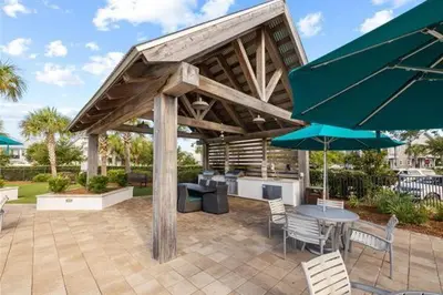 a patio with a table and chairs and an umbrella at The Tipsy Turtle in Inlet Beach