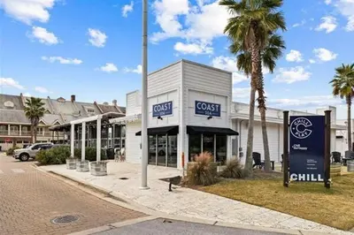 a store on a street with palm trees and a building at The Tipsy Turtle in Inlet Beach
