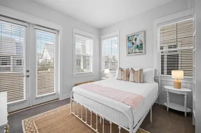 a white bedroom with a bed and windows at Mermaid Day in Inlet Beach