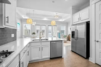 a kitchen with white cabinets and a stainless steel refrigerator at Mermaid Day in Inlet Beach