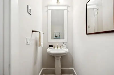 a white bathroom with a sink and a mirror at Selah by the Sea in Inlet Beach
