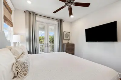 a bedroom with a bed and a flat screen tv at Selah by the Sea in Inlet Beach