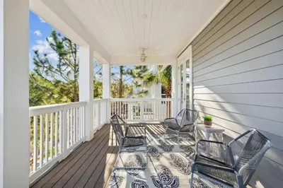 a porch with two chairs and a table at Selah by the Sea in Inlet Beach