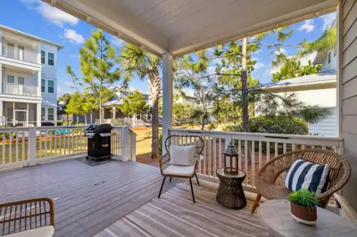 a screened porch with chairs and a grill at Selah by the Sea in Inlet Beach
