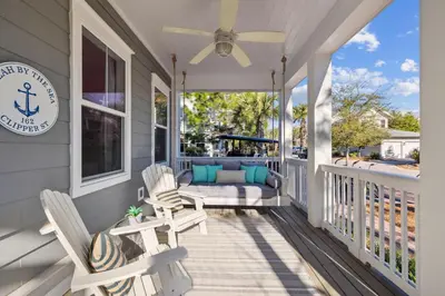 a porch with two chairs and a fan at Selah by the Sea in Inlet Beach