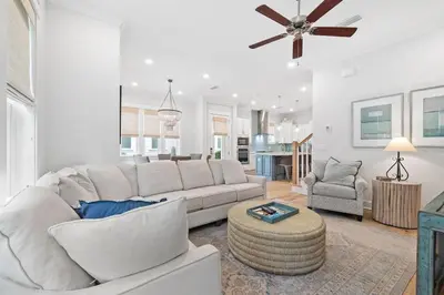 a living room with a white couch and a ceiling fan at Suits Us in Inlet Beach