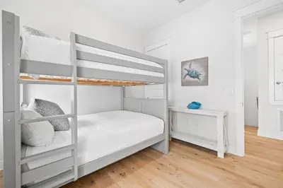 a bedroom with two bunk beds and a wooden floor at Suits Us in Inlet Beach