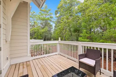 a porch with a chair on a wooden deck at Suits Us in Inlet Beach