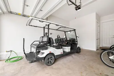 a golf cart parked in a room with a hose at Suits Us in Inlet Beach