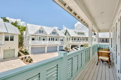 a large house with a blue railing on a deck at No Worries, Beach Happy in Inlet Beach