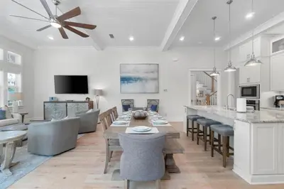 a kitchen and living room with a table and chairs at Sunset Key in Inlet Beach