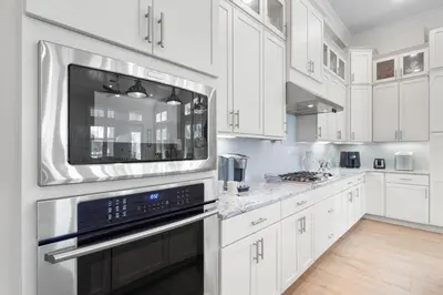 a kitchen with white cabinets and a large microwave at Sunset Key in Inlet Beach