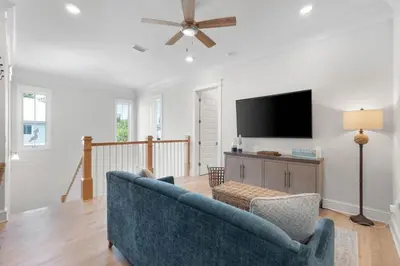 a living room with a blue couch and a flat screen tv at Sunset Key in Inlet Beach