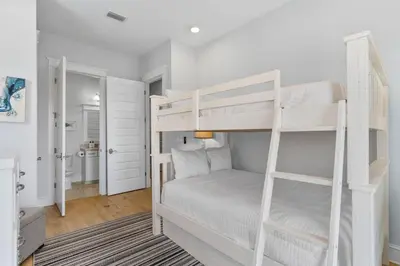 a bedroom with two bunk beds and a bathroom at Sunset Key in Inlet Beach
