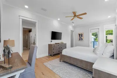 a white bedroom with a bed and a television at Sunset Key in Inlet Beach