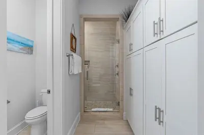 a white bathroom with a toilet and a shower at Sunset Key in Inlet Beach
