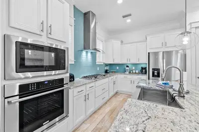 a large kitchen with white cabinets and appliances at Sunkissed on 30A in Inlet Beach