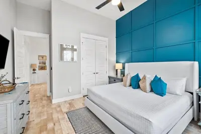 a bedroom with a large white bed with blue walls at Sunkissed on 30A in Inlet Beach